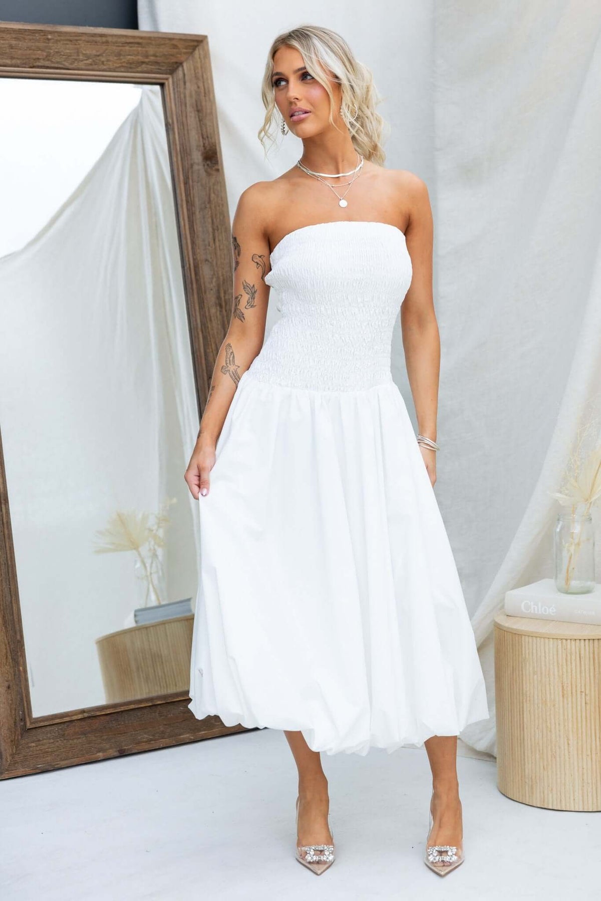 Stylish strapless Cadro midi dress with elastic bodice, showcasing a chic white design. Perfect for any occasion.