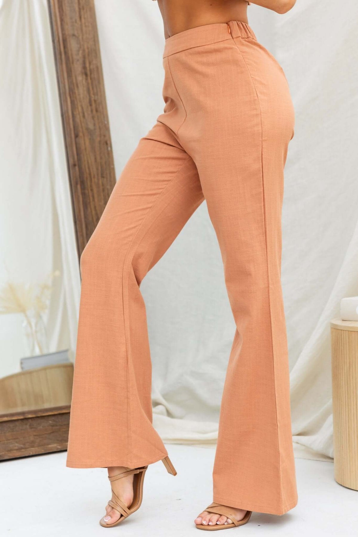 Stelline Pants featuring a mid-high waist, elastic back, and linen look in a stylish rust color.