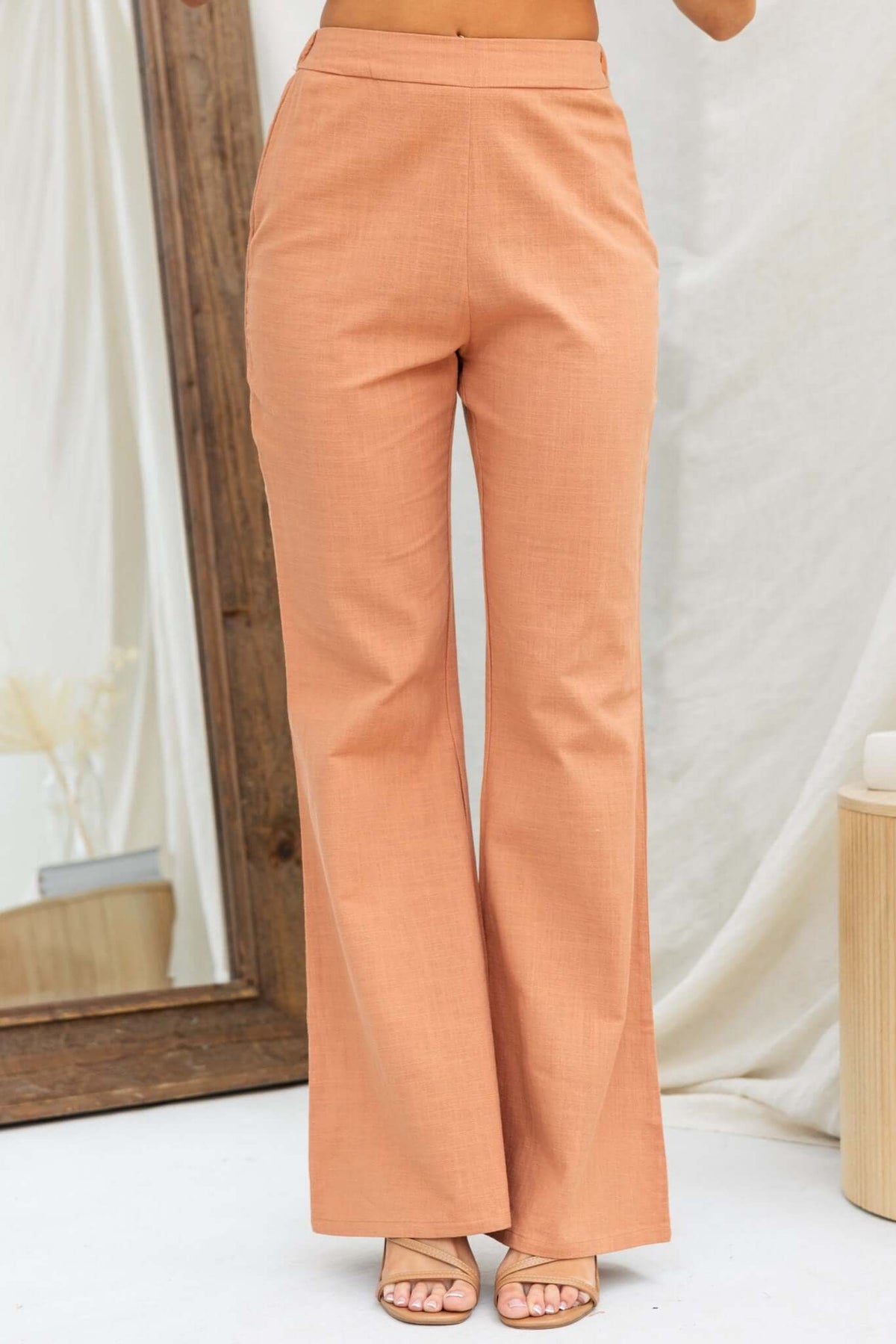 Stylish Stelline Pants in warm peach, featuring a mid-high waist fit and invisible side zip, perfect for a chic look.