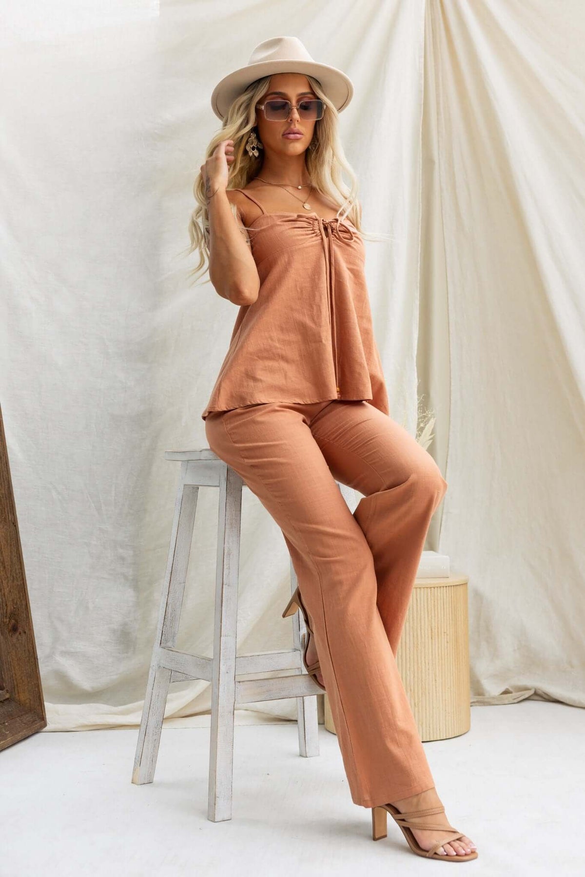 Model in stylish terracotta Stelline Pants and matching top, showcasing a relaxed fit and elegant summer vibe.