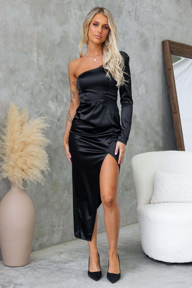 A model wearing a stylish black Rommey maxi dress with a one-shoulder neckline and asymmetric hemline.