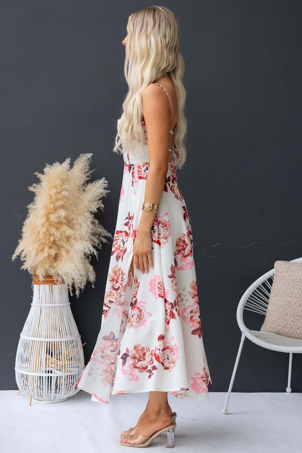 Side view of a woman wearing the Burkes Midi Dress with floral print, adjustable straps, and a stylish front split.