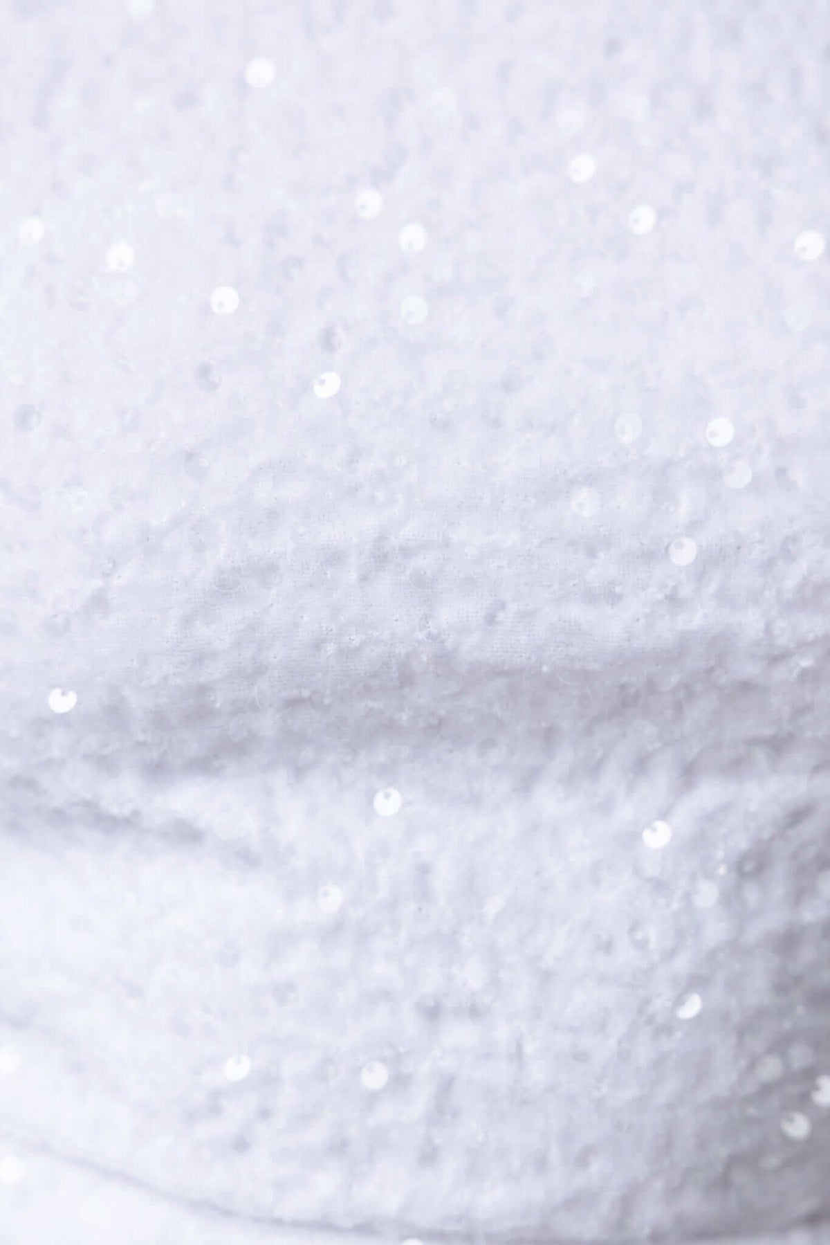 Close-up of Nerissa Dress fabric featuring shimmering white sequins and a textured pattern.