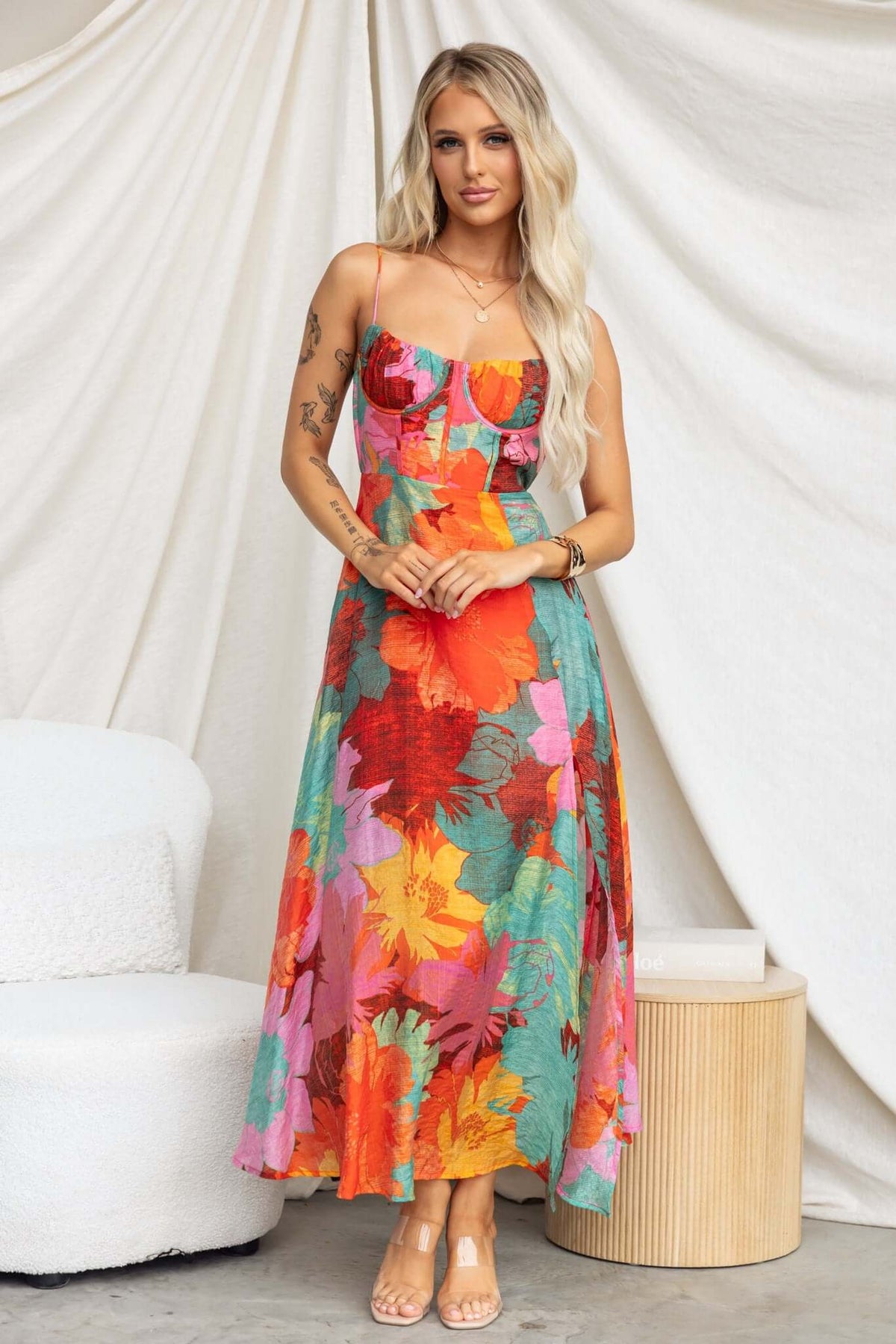Burkes Midi Dress in vibrant floral print, featuring adjustable tie straps and a front split, styled for a casual summer look.