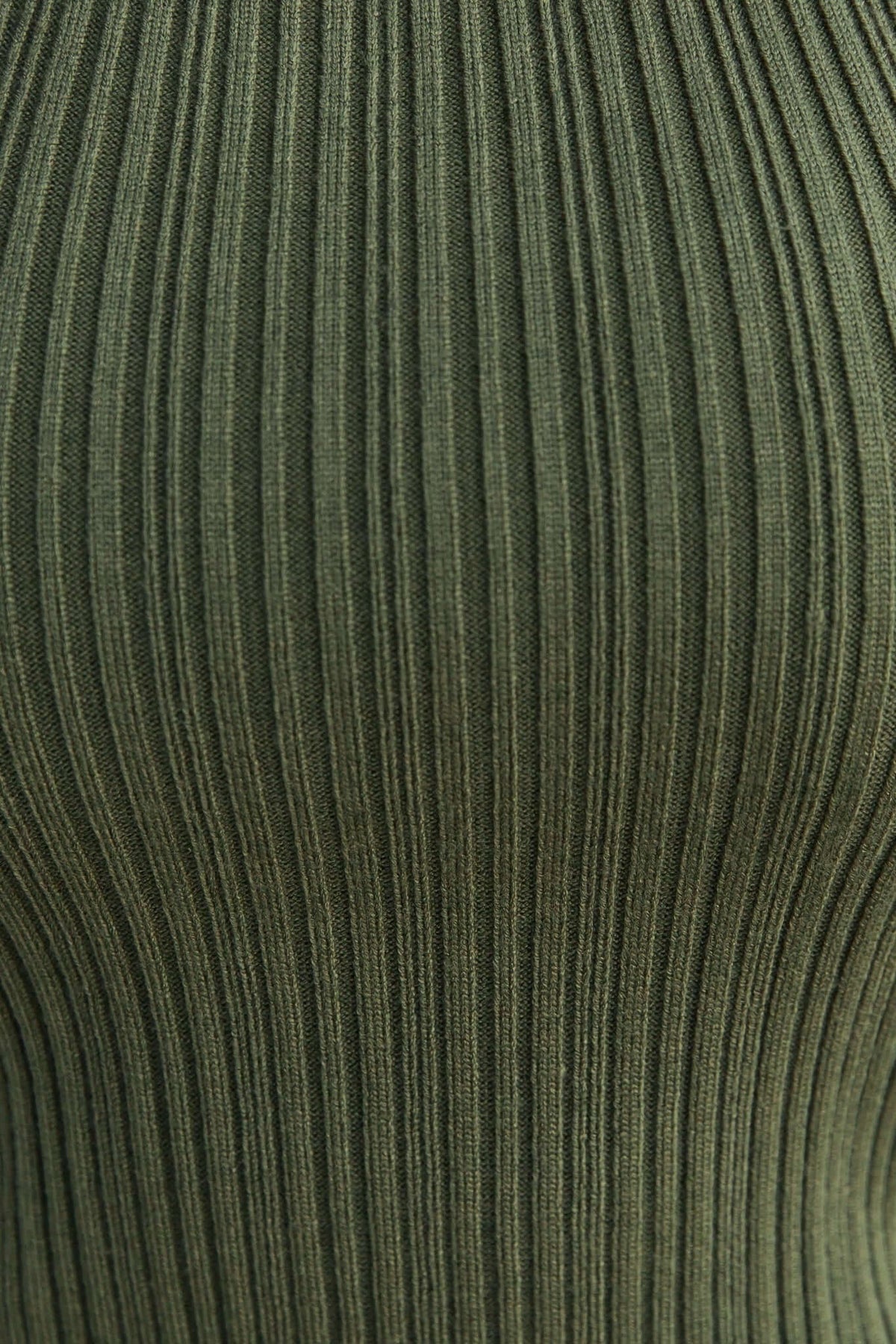 Close-up of ribbed green knit fabric, showcasing texture and stretch of the Socker Top.