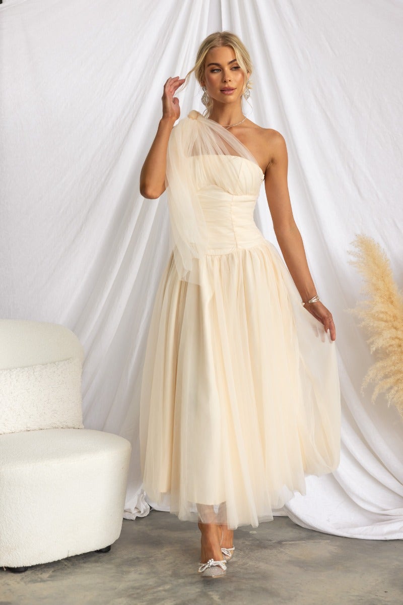 Belle Maxi Dress featuring a one-shoulder neckline and tulle overlay in soft beige, elegantly styled for special occasions.