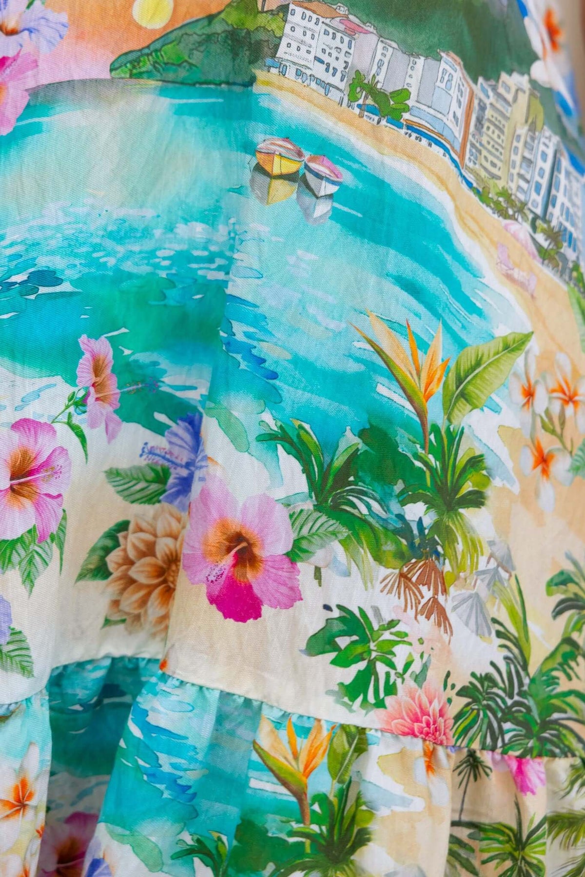 Colorful floral print fabric of the Barlowe Midi Dress featuring a beach scene and vibrant tropical flowers.