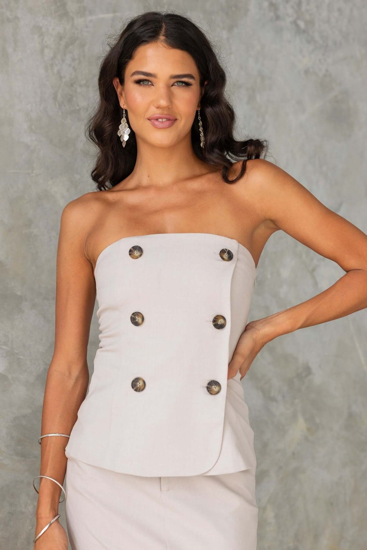 Model in strapless Lanetta Top with buttons, showcasing a chic and stylish summer look.