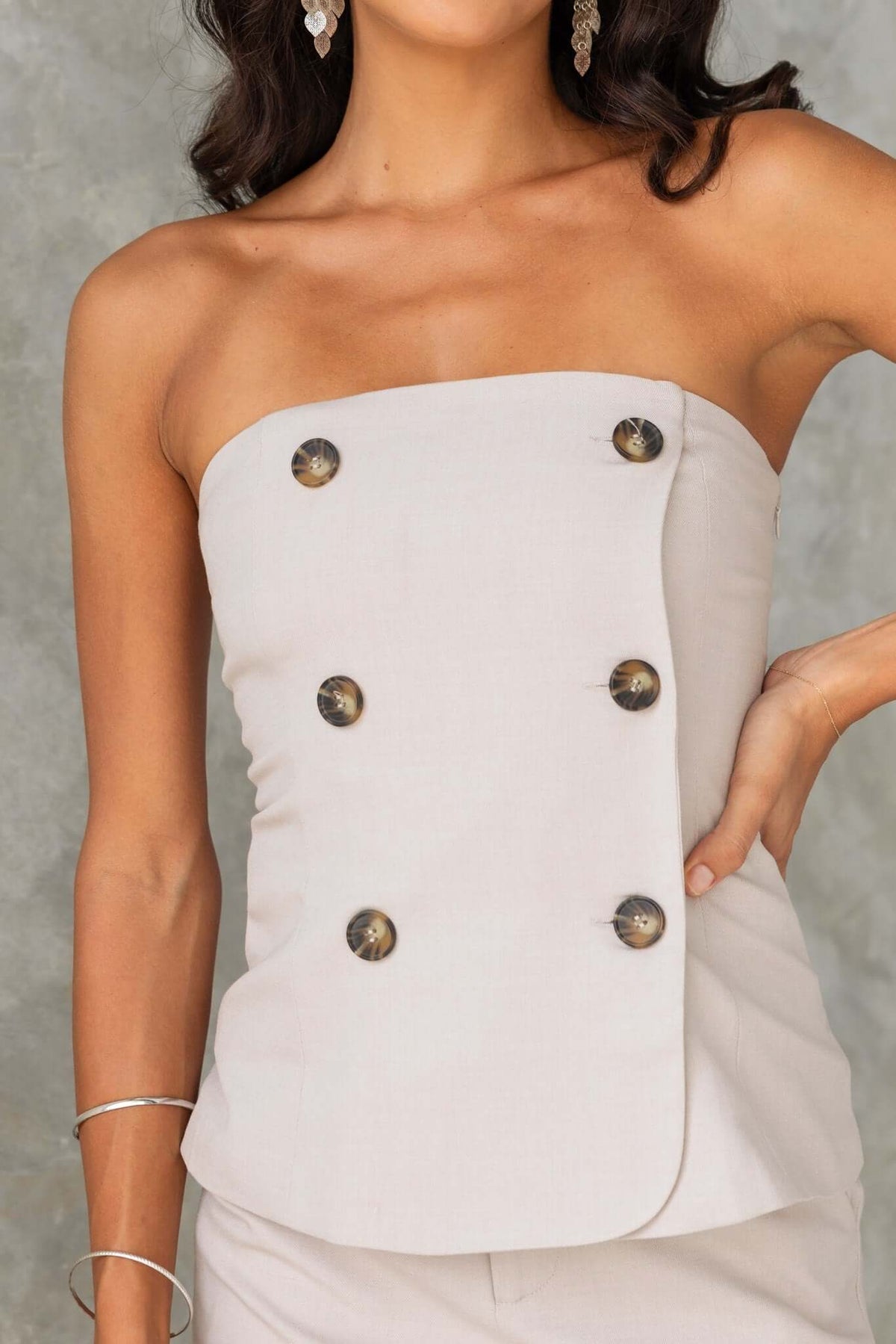 Strapless Lanetta Top in light beige with non-functional buttons and invisible side zip, perfect for stylish summer wear.