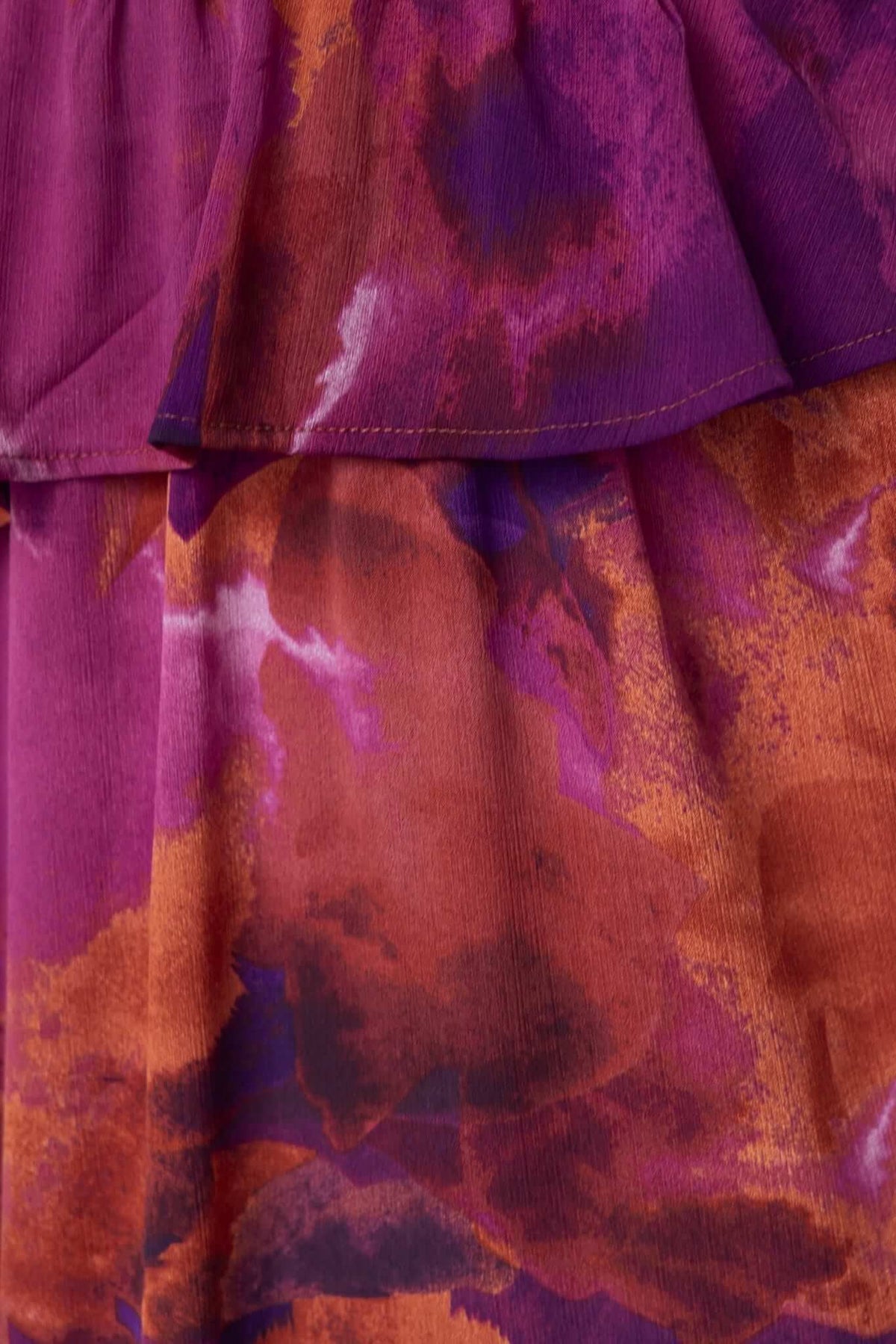 Close-up of the Jaycee Maxi Dress showing vibrant purple and orange floral fabric detail.