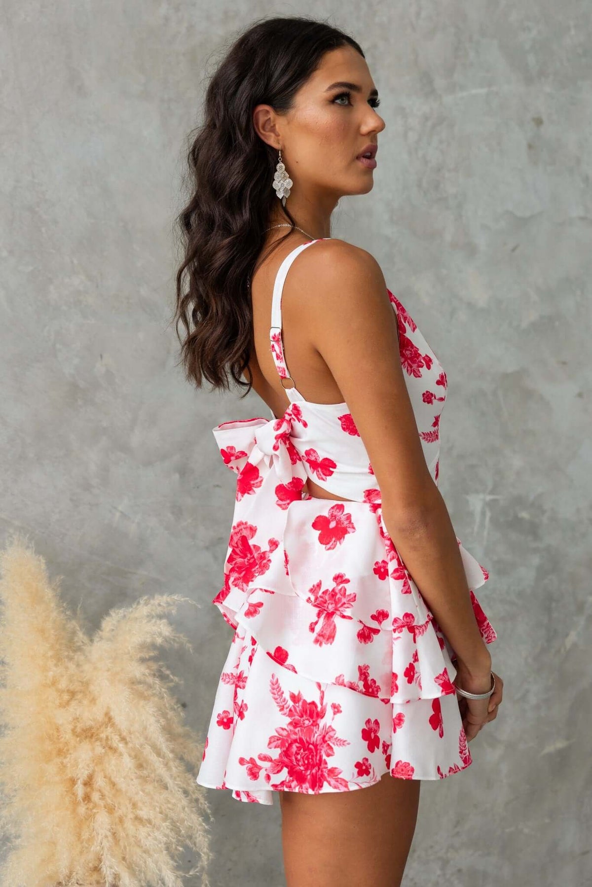 Model showcasing By Your Side Playsuit with floral design, adjustable straps, and tie-back detail.