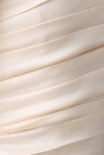 Close-up of pleated satin fabric from a strapless Pontiac Maxi Dress in a soft beige tone.
