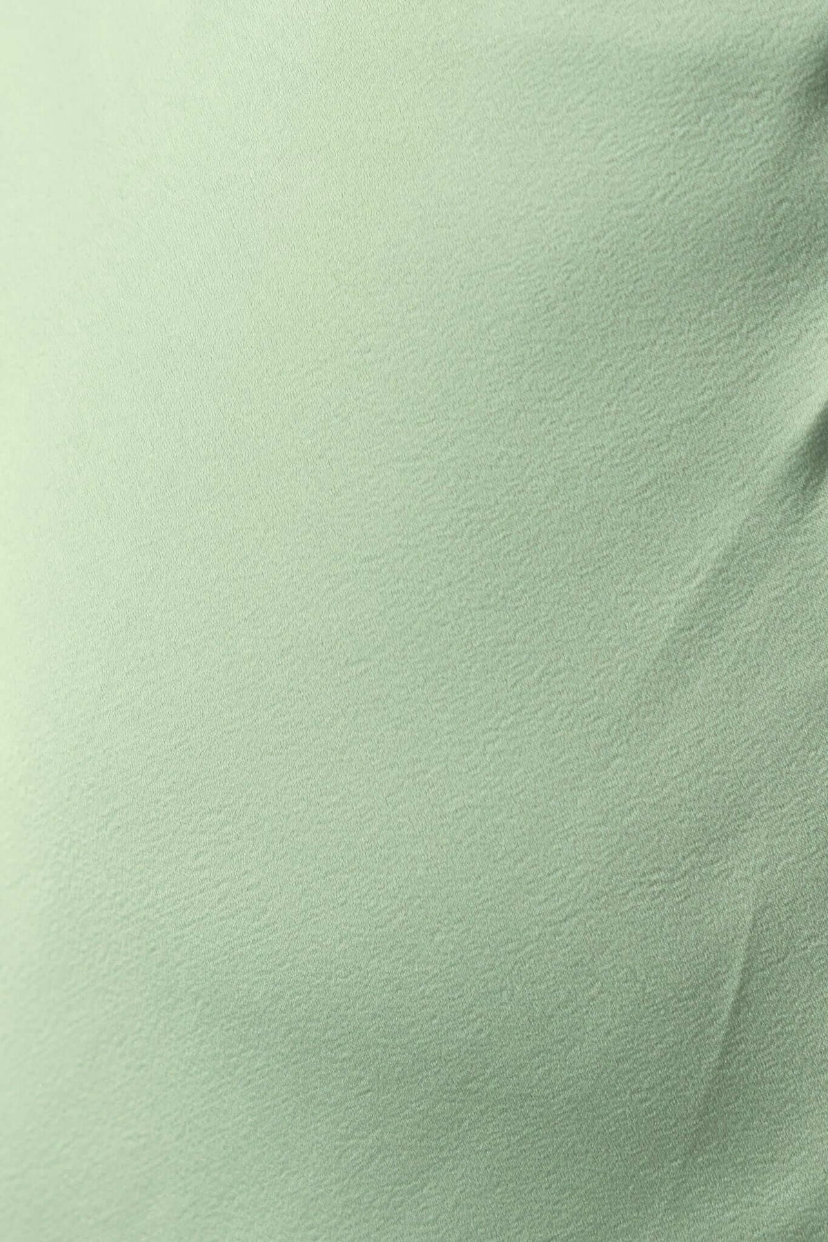 Close-up of the soft, textured mint green fabric of the Farida Maxi Dress, highlighting its gentle color and quality.