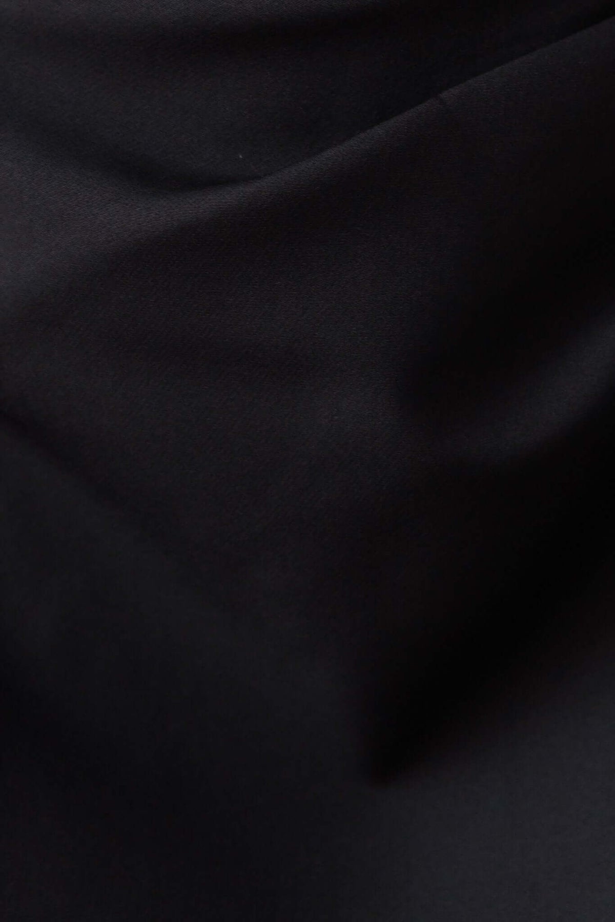 Close-up of smooth black fabric, showcasing the texture and quality suitable for a stylish dress.