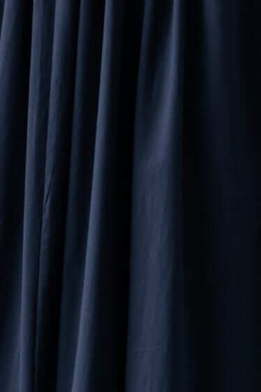 Close-up of navy fabric folds from the Rowena Maxi Dress, showcasing its soft texture and elegant drape.