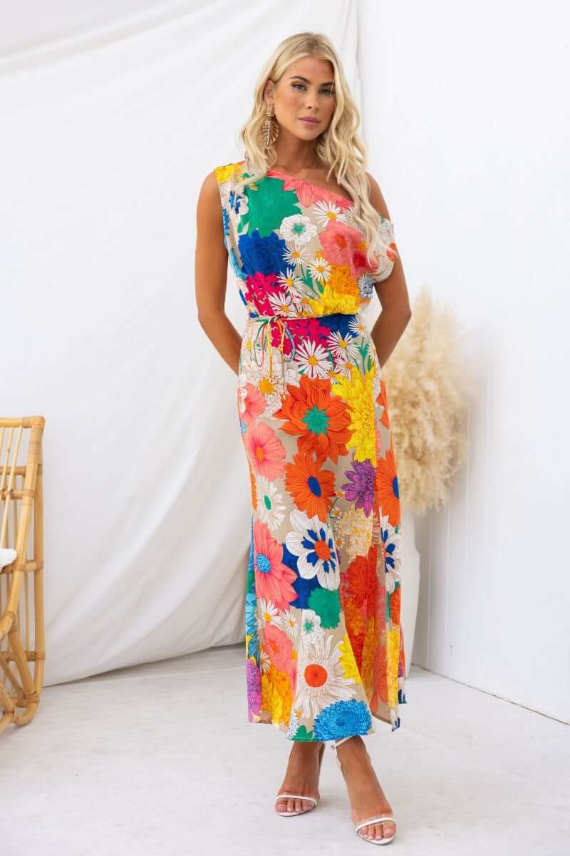 Sicilian Sun Maxi Dress featuring vibrant floral prints, asymmetric neckline, and a front split, perfect for summer styling.