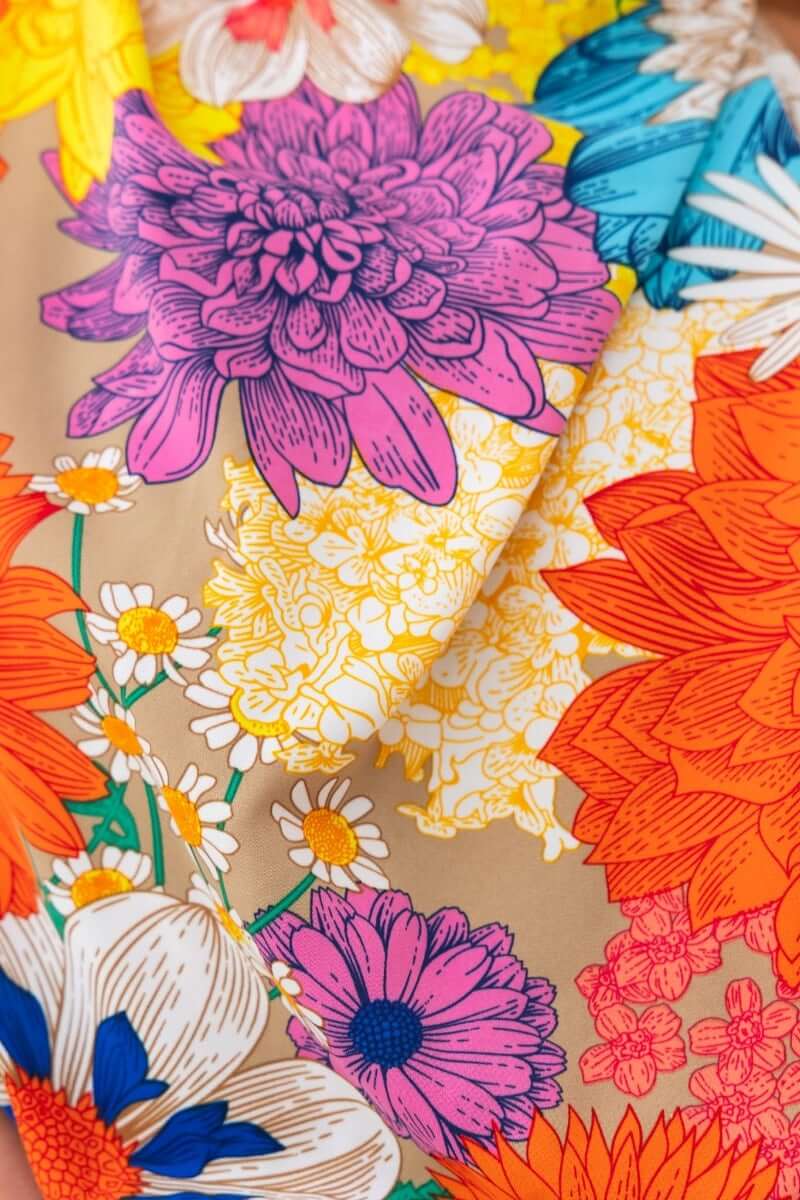 Close-up of vibrant floral print featuring pink, orange, and yellow flowers on fabric for Sicilian Sun Maxi Dress.