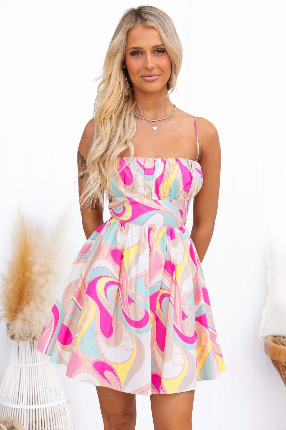 Model wearing Tarnee Dress with adjustable straps and colorful abstract print, perfect for summer outings.