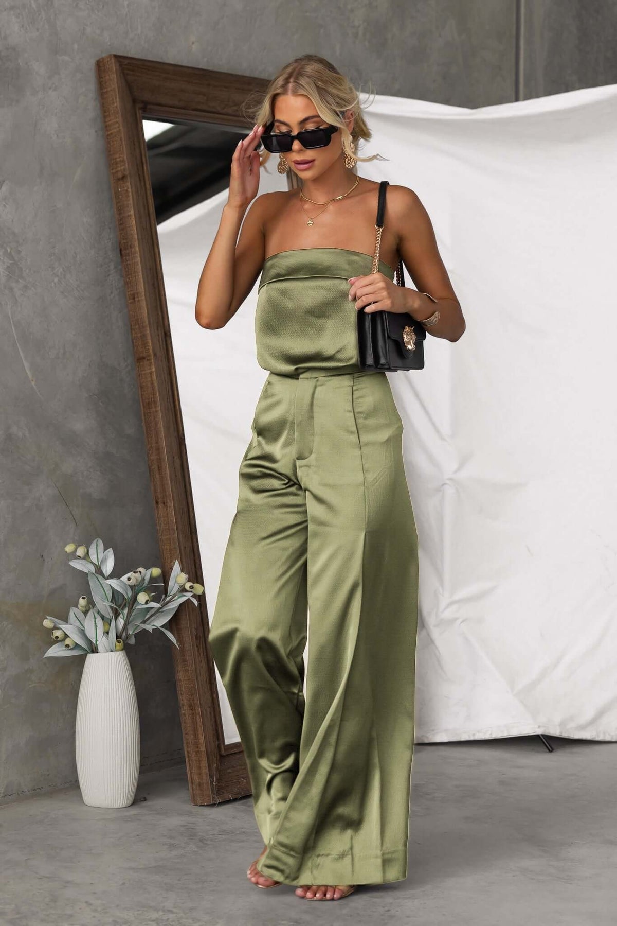 Model showcasing Hampton Style Pants in olive green, mid-high waist with pockets, paired with a chic top and accessories.