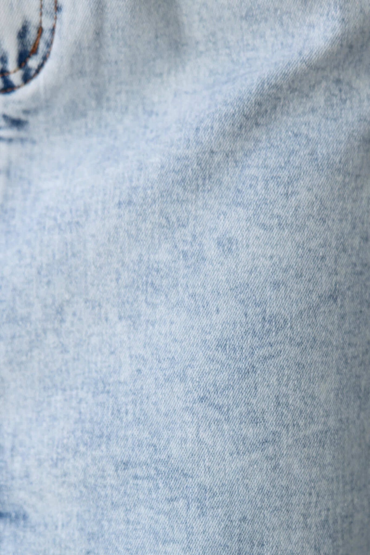 Close-up of soft denim fabric texture, showcasing light blue color for Kella Denim Midi Skirt.