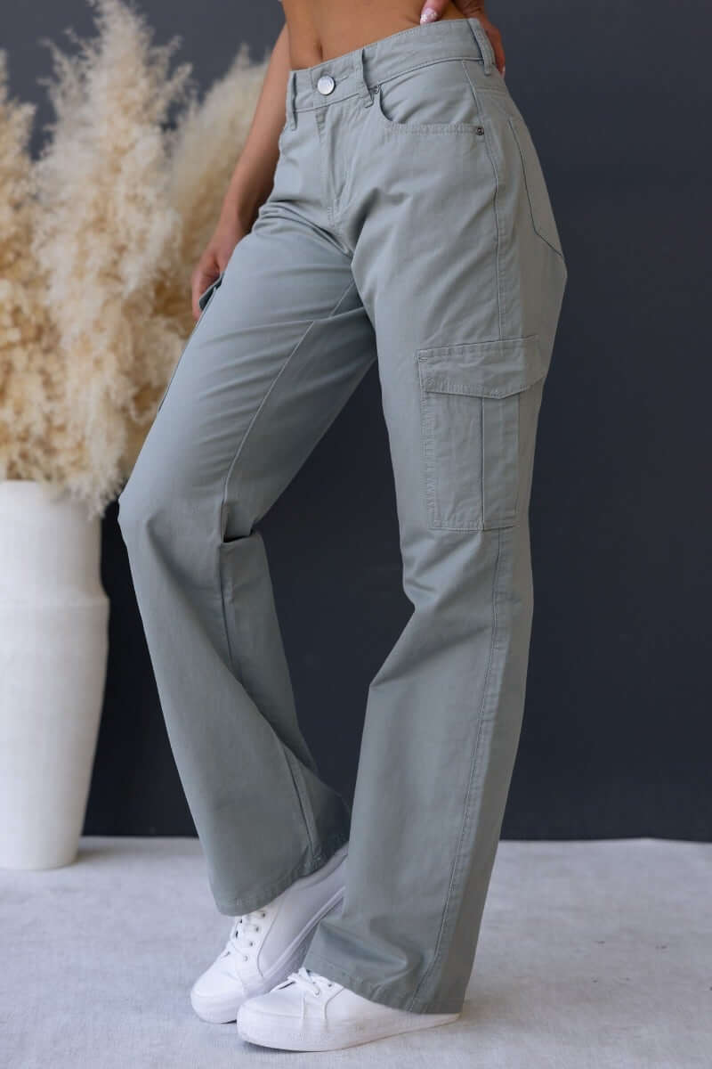 Bowie cargo pants in sage green, featuring wide legs and multiple pockets, styled with white sneakers.