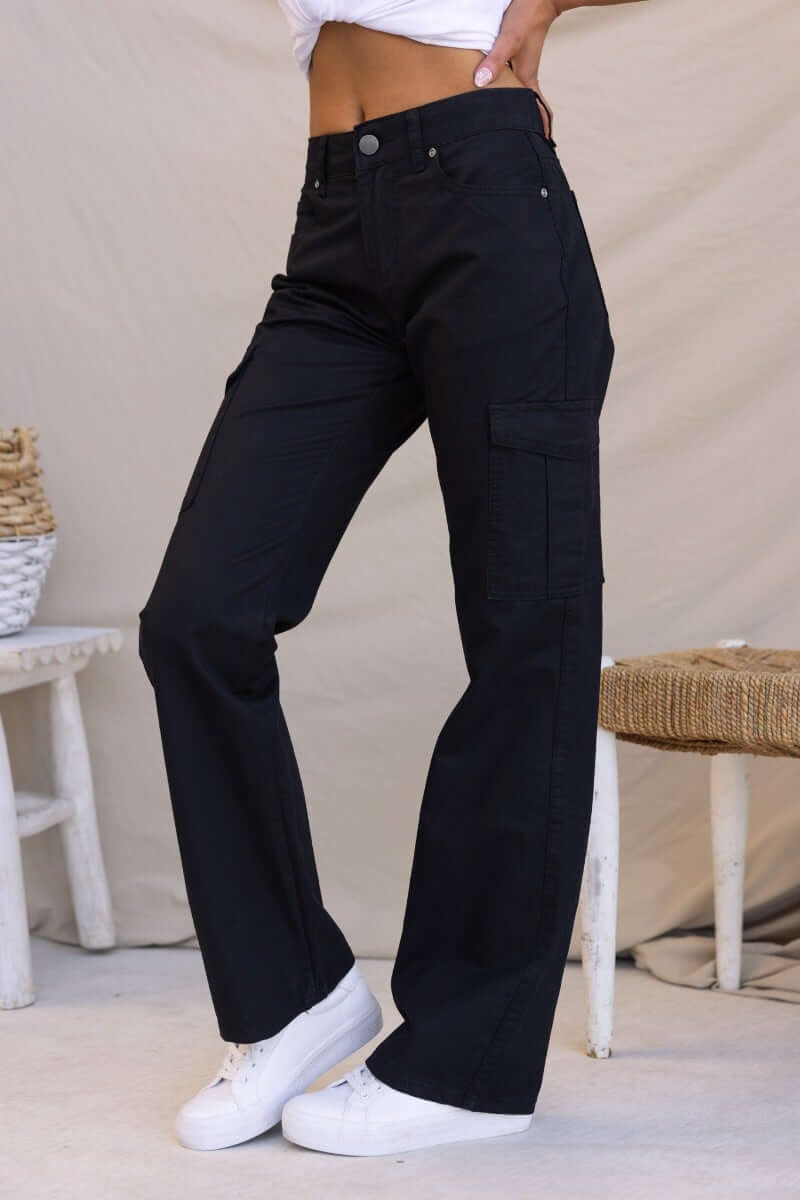 Black Bowie Cargo Pants featuring a low-mid waist fit and wide legs, styled with white sneakers.