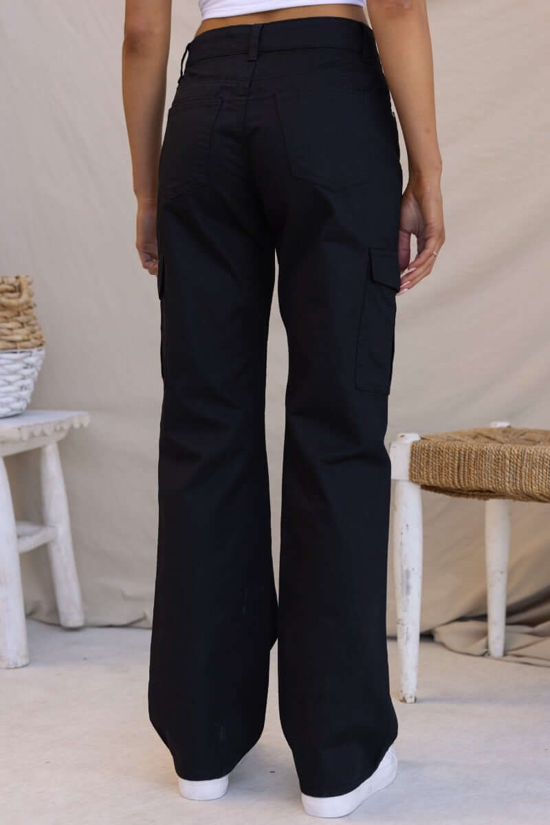 Back view of black Bowie cargo pants showcasing wide legs and side pockets.