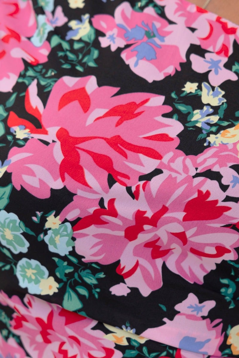 Close-up of vibrant black floral print featuring pink and red flowers on a Karana Maxi Dress.