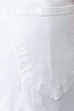 Close-up of a white denim jeans back pocket design, showcasing the stitching and fabric texture.