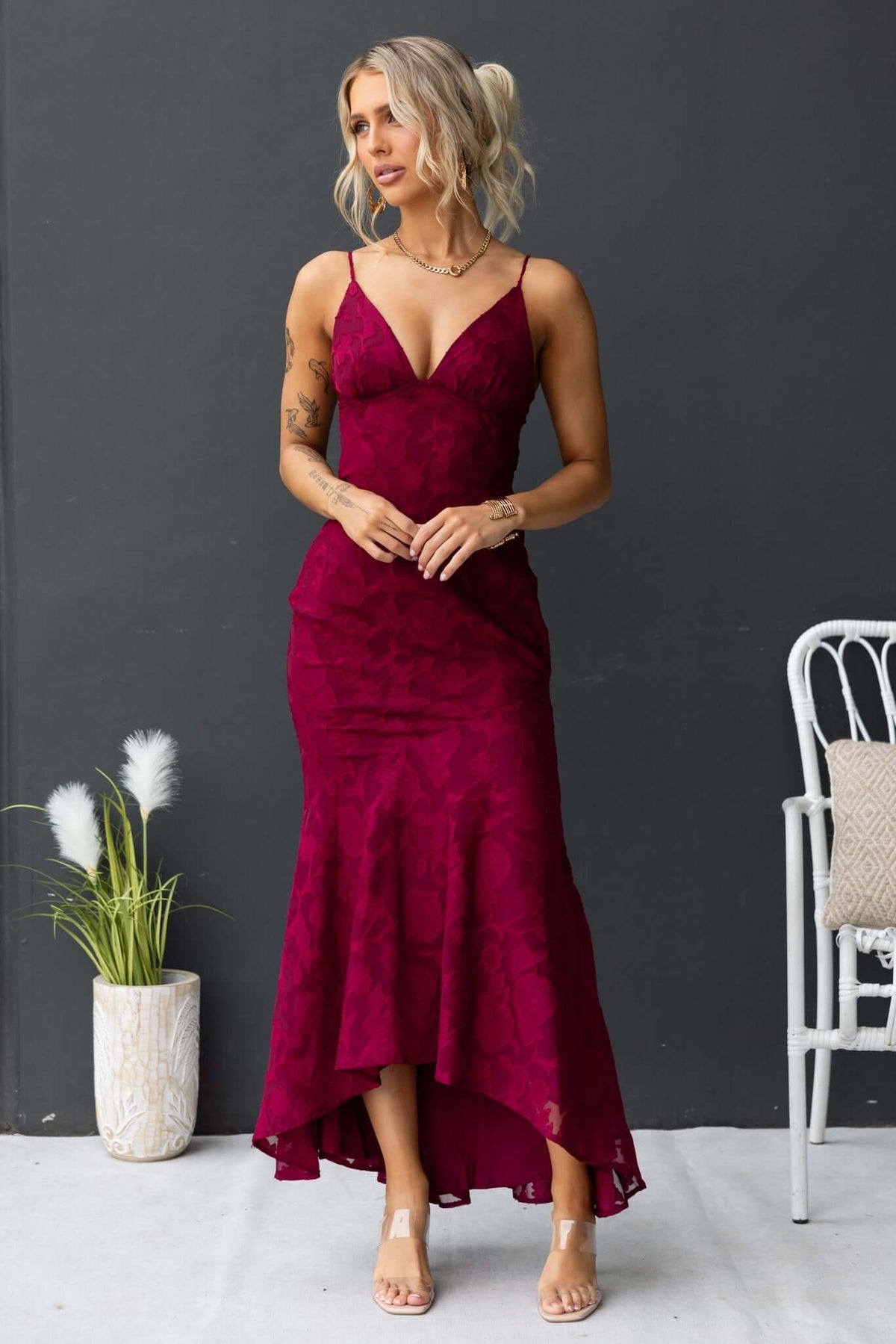 Burgundy Fontana Maxi Dress with adjustable straps and high-low hem, styled with minimal accessories.