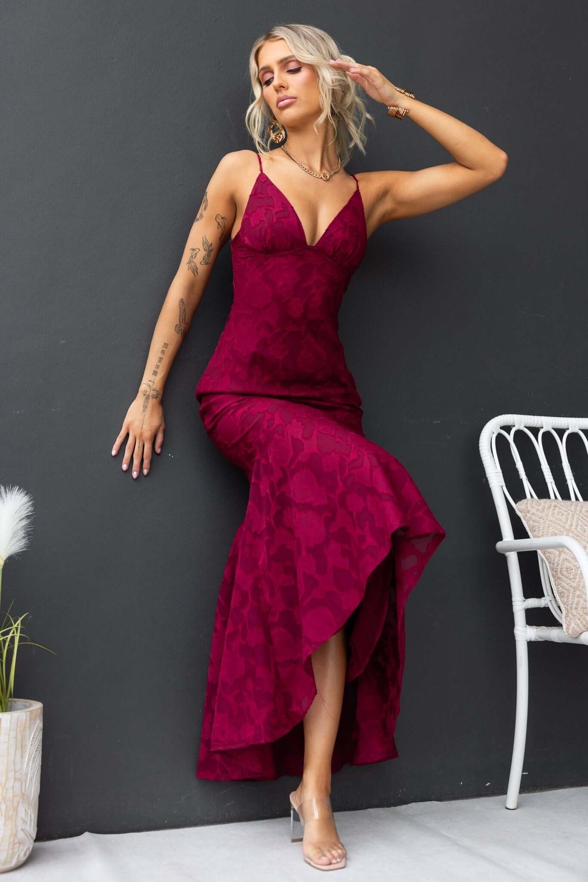 Fontana Maxi Dress in burgundy with adjustable straps and high-low hem, worn by a model against a dark background.