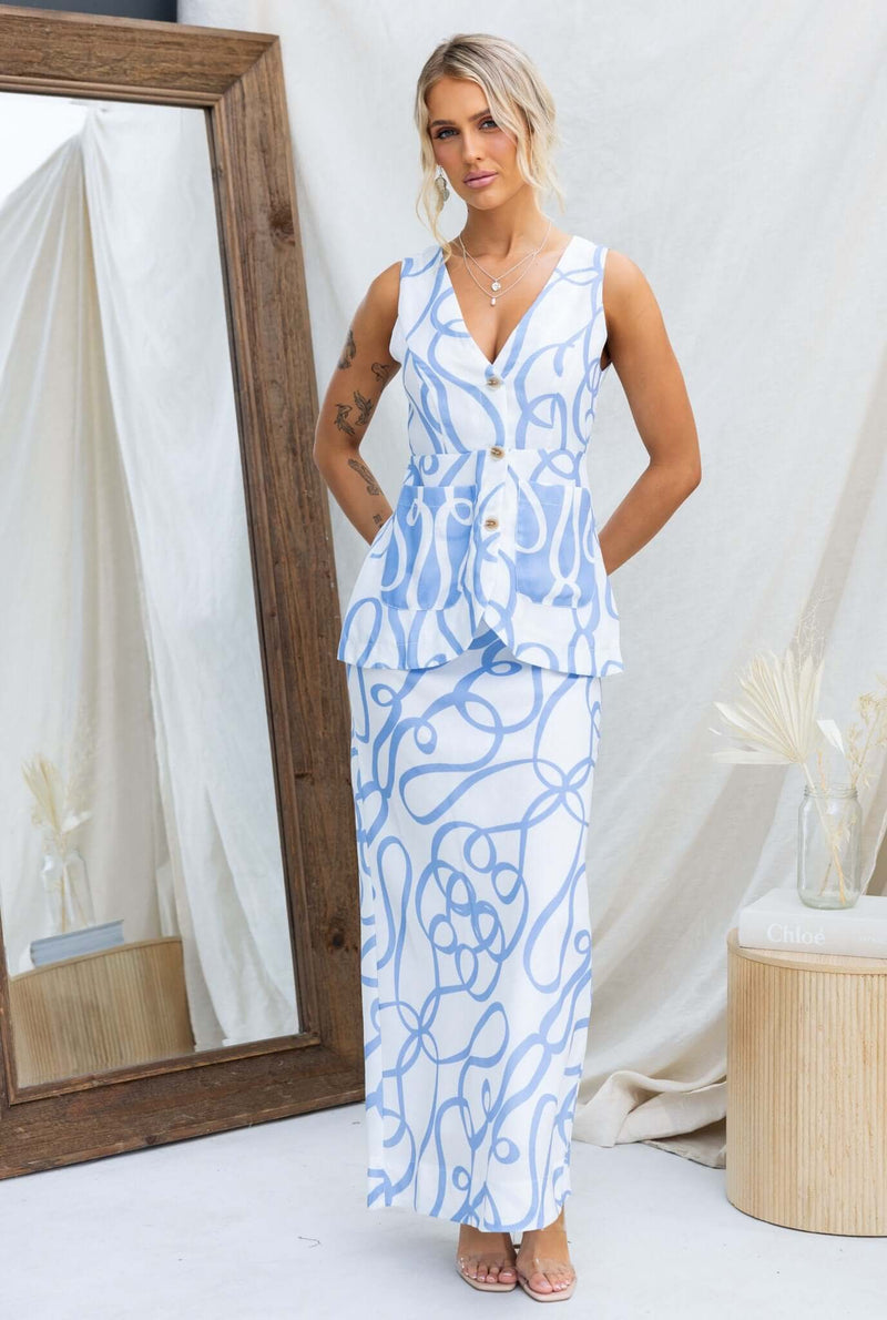 Model wearing a stylish Bexley Maxi Skirt with a blue and white design, showcasing a mid-high waist fit and elegant silhouette.