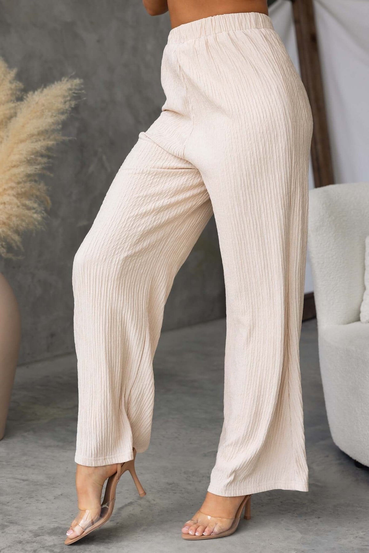 Lisa Pants in light beige with a mid-high waist and elastic waistband, styled with a relaxed fit.