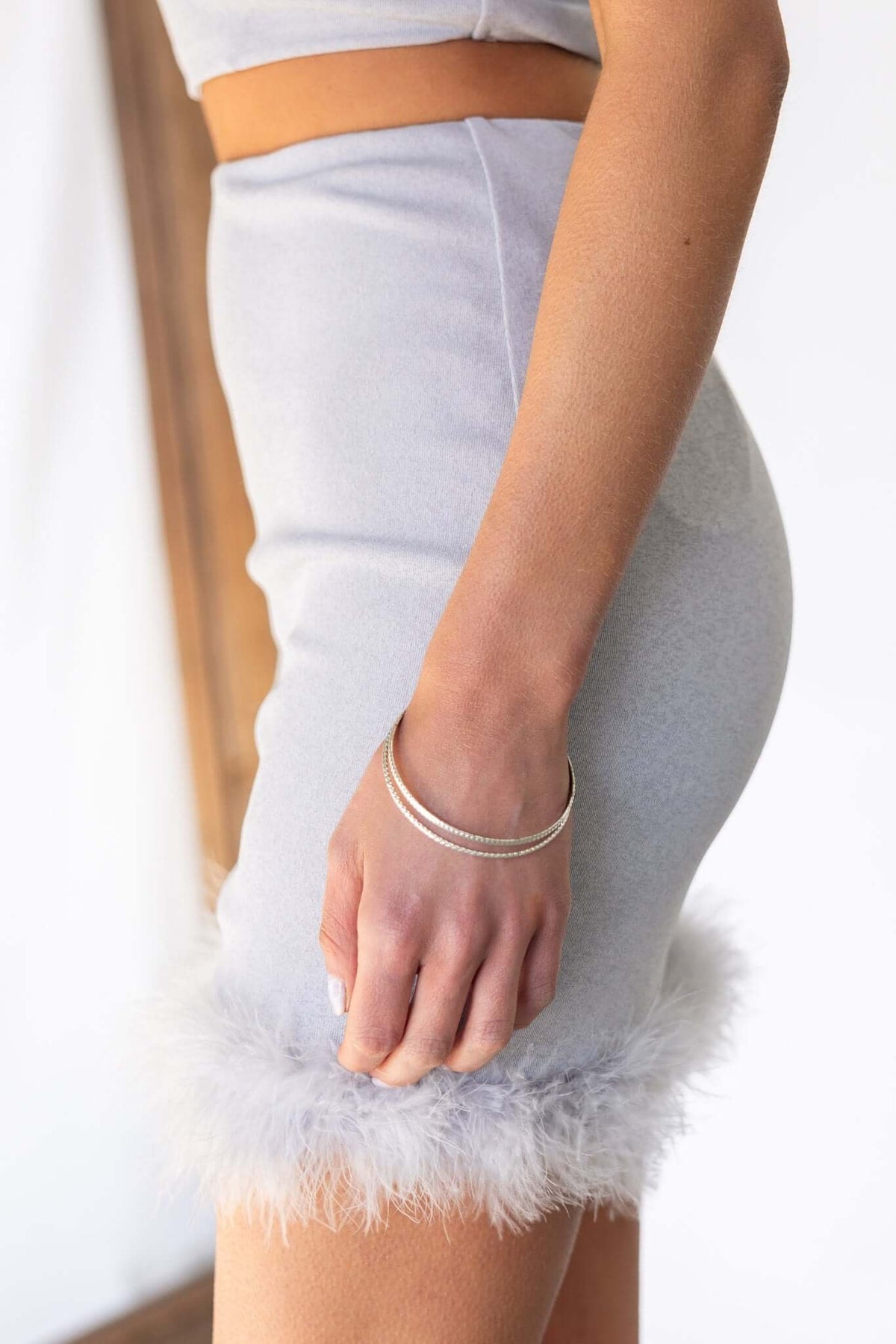 Close-up of a grey mid-high waist Idol Skirt featuring feather trim and a fitted design.