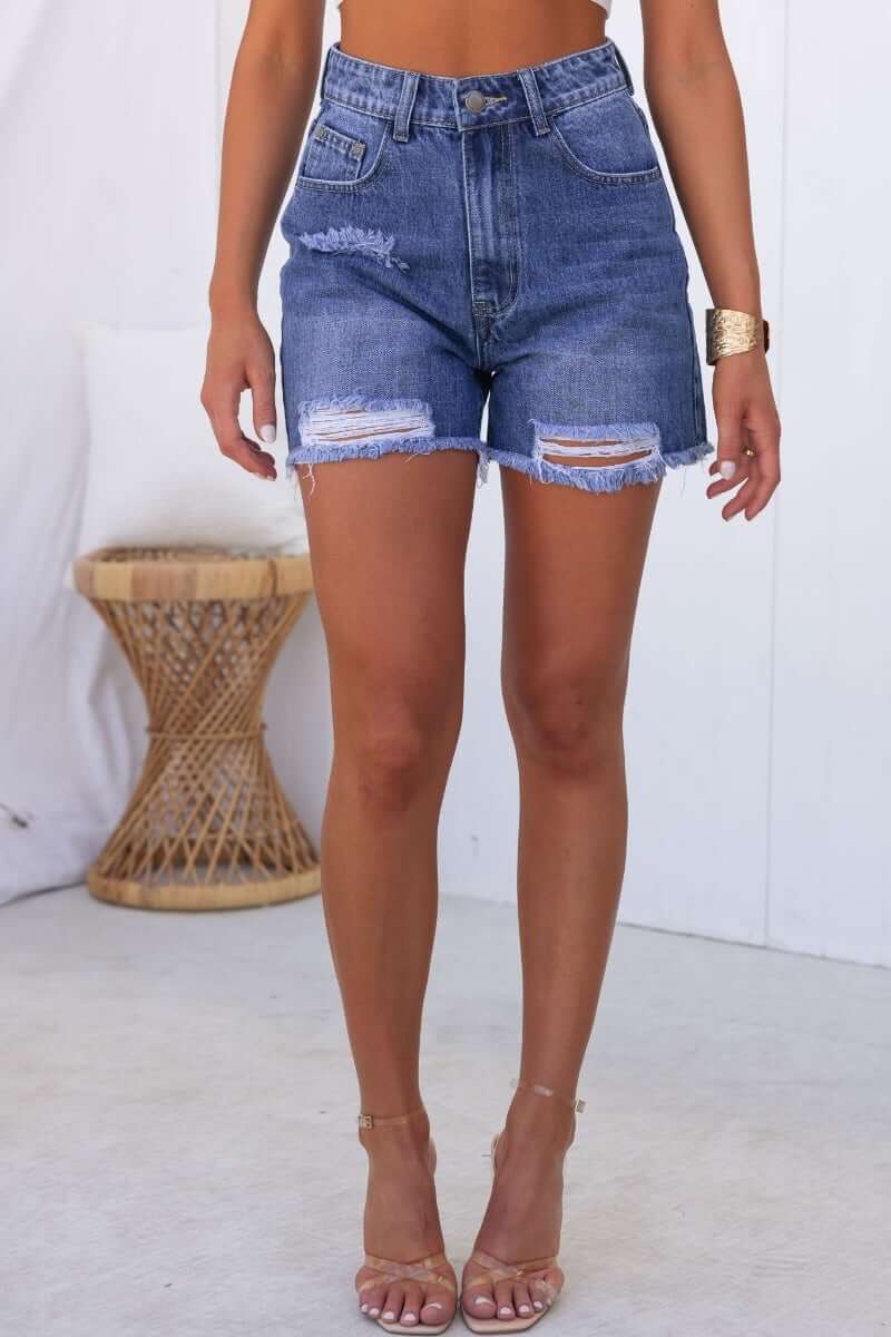 Kobe Denim Shorts featuring distressed rips, frayed hemline, and front/back pockets for a stylish summer look.