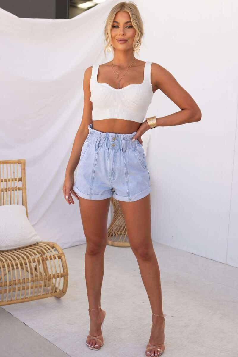 Model wearing Hattie Paper Bag Denim Shorts with elastic waistband and two-button closure, styled with a white top.