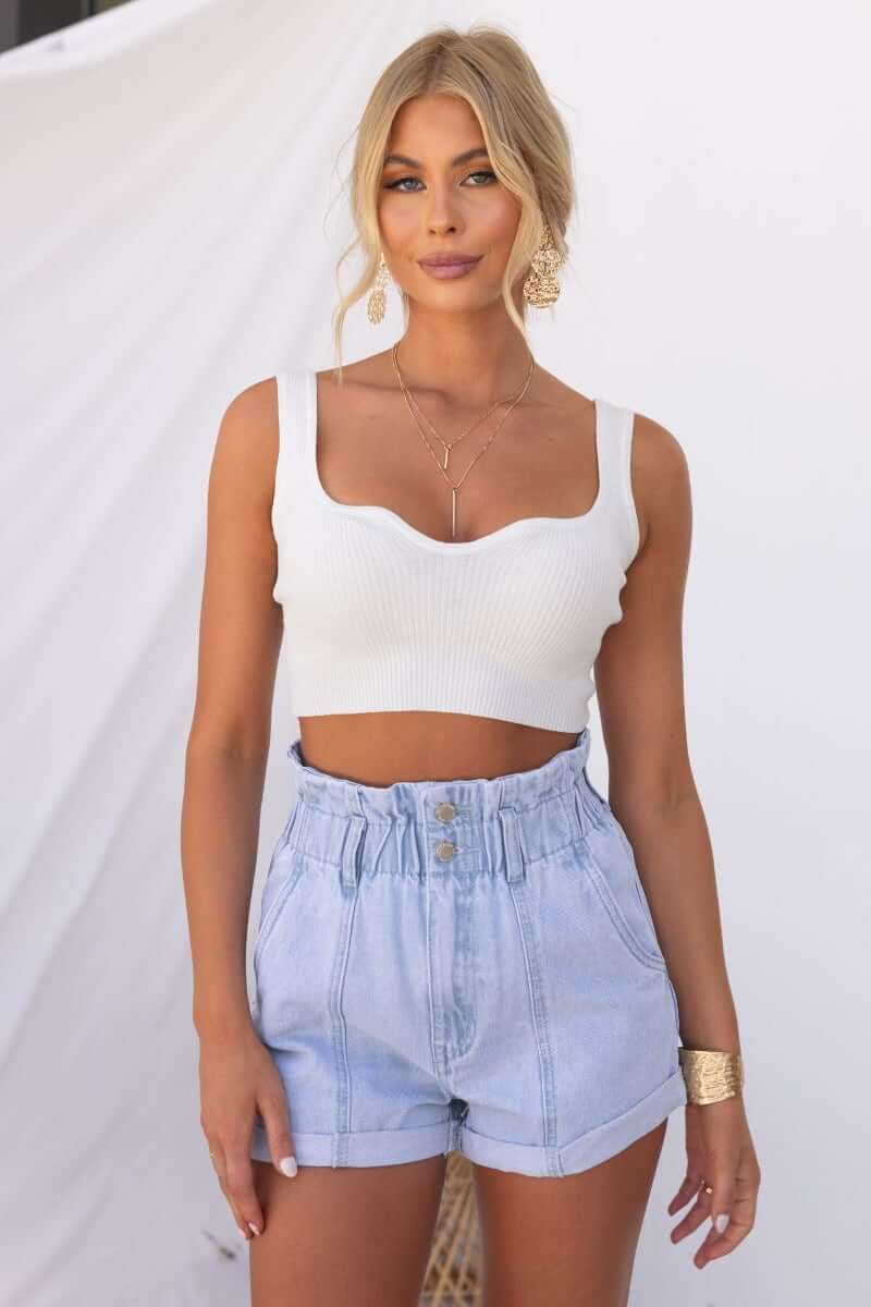 Woman wearing Hattie Paper Bag Shorts with a stylish white crop top, featuring a paperbag waist and pockets.