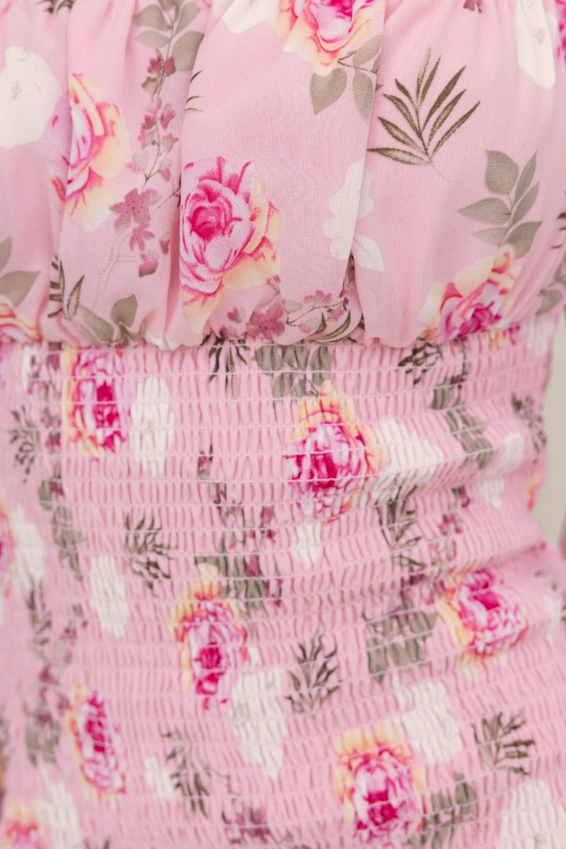 Close-up of Arabella Midi Dress showcasing pink floral design, elastic fittings, and smocked bodice details.