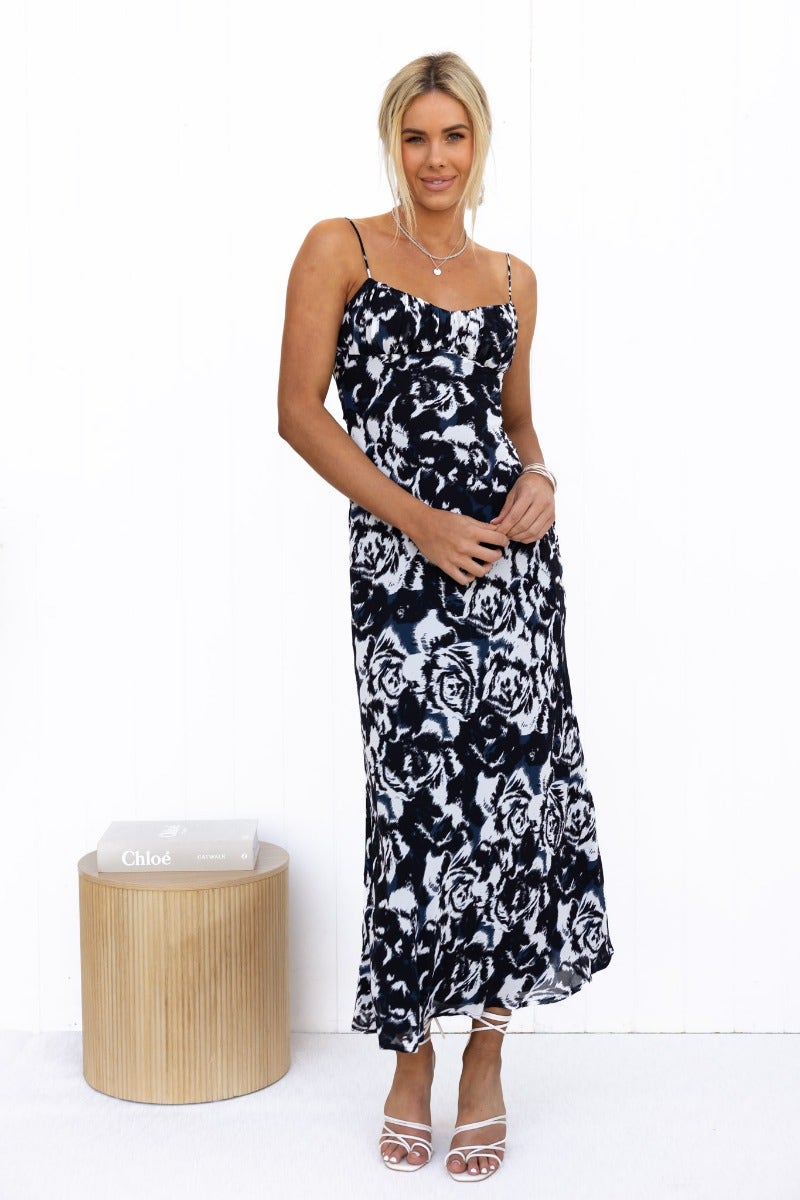 Model wearing Freyda Maxi Dress, a black and white floral maxi with adjustable straps and cut-out back.