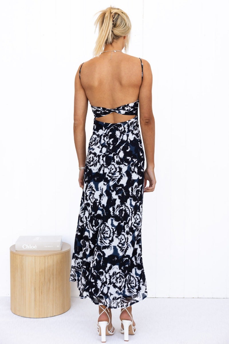 Model wearing Freyda Maxi Dress, a black multi-colour floral dress with adjustable straps and cut-out back.