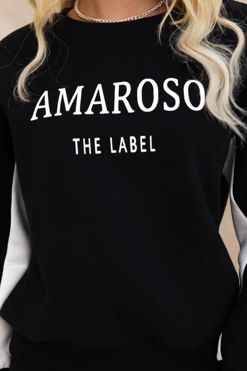 Black Amaroso the Label jumper featuring round neckline and ribbed cuffs, model wearing size 6/XS.