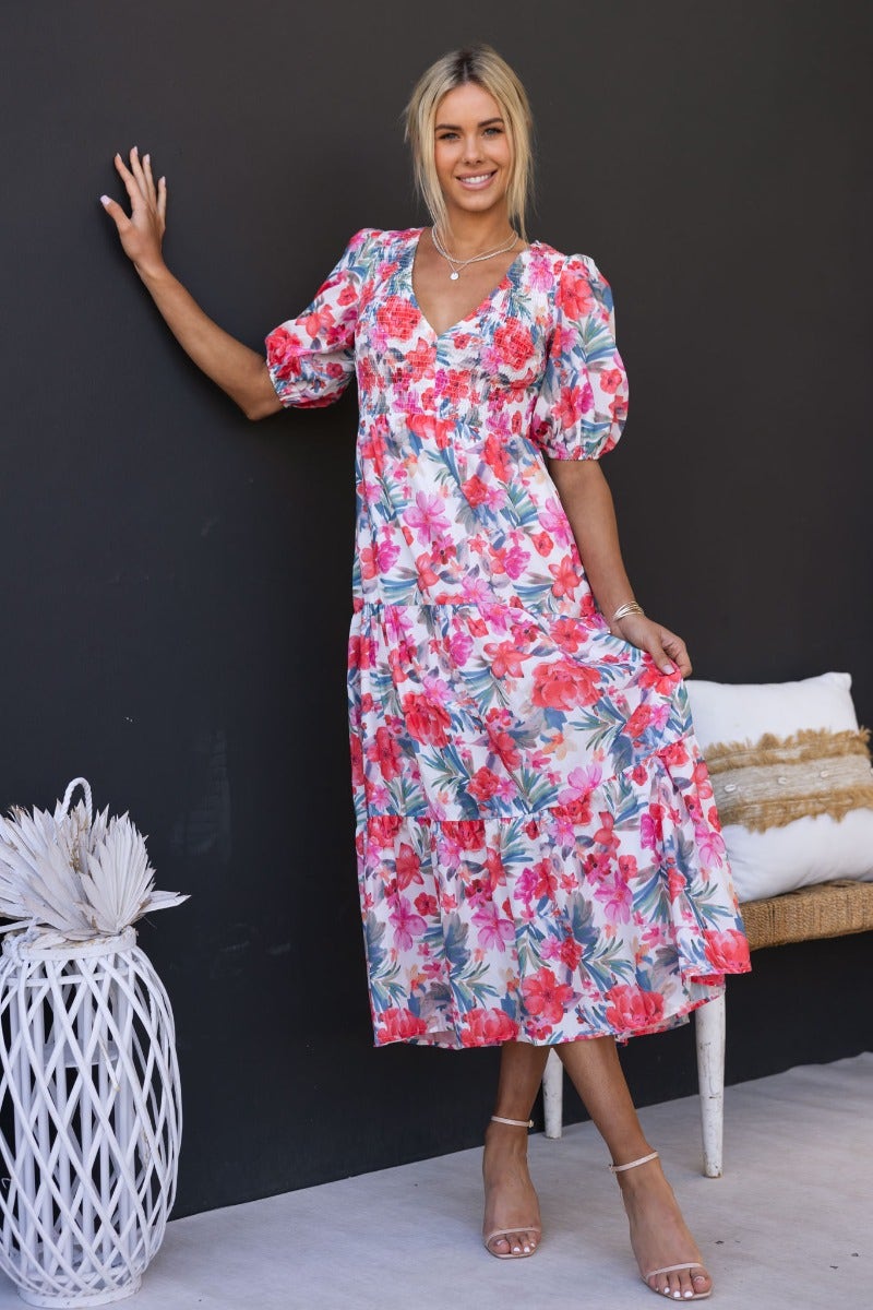 Model in floral print Ave Maxi Dress with V-neckline and puff sleeves, showcasing a stylish summer look.