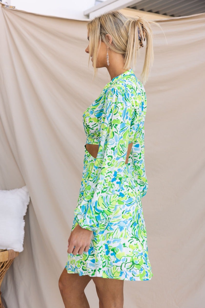 Model wearing the Warm Embrace Dress, featuring a vibrant floral print and a cut-out waist design.