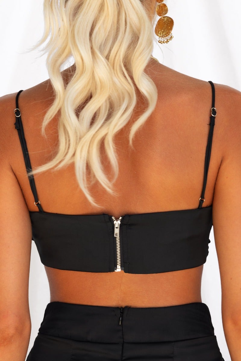 Back view of a black satin Show Stopper top with thin adjustable straps and a zip closure.