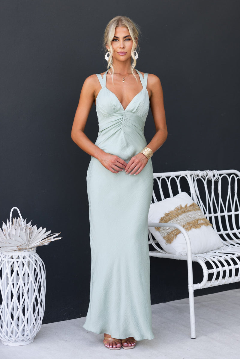 Model wearing Laken Maxi Dress in soft green, featuring adjustable straps, lightly textured fabric, and a fitted silhouette.