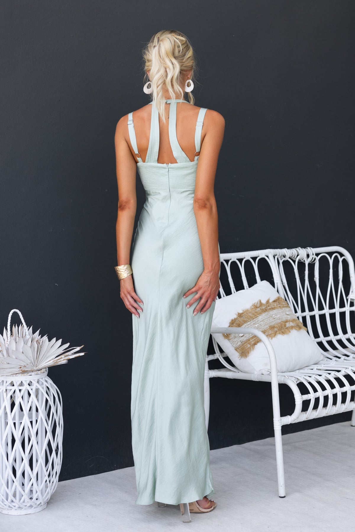 Back view of a woman wearing a light green Laken Maxi Dress with adjustable straps and invisible zip detail.