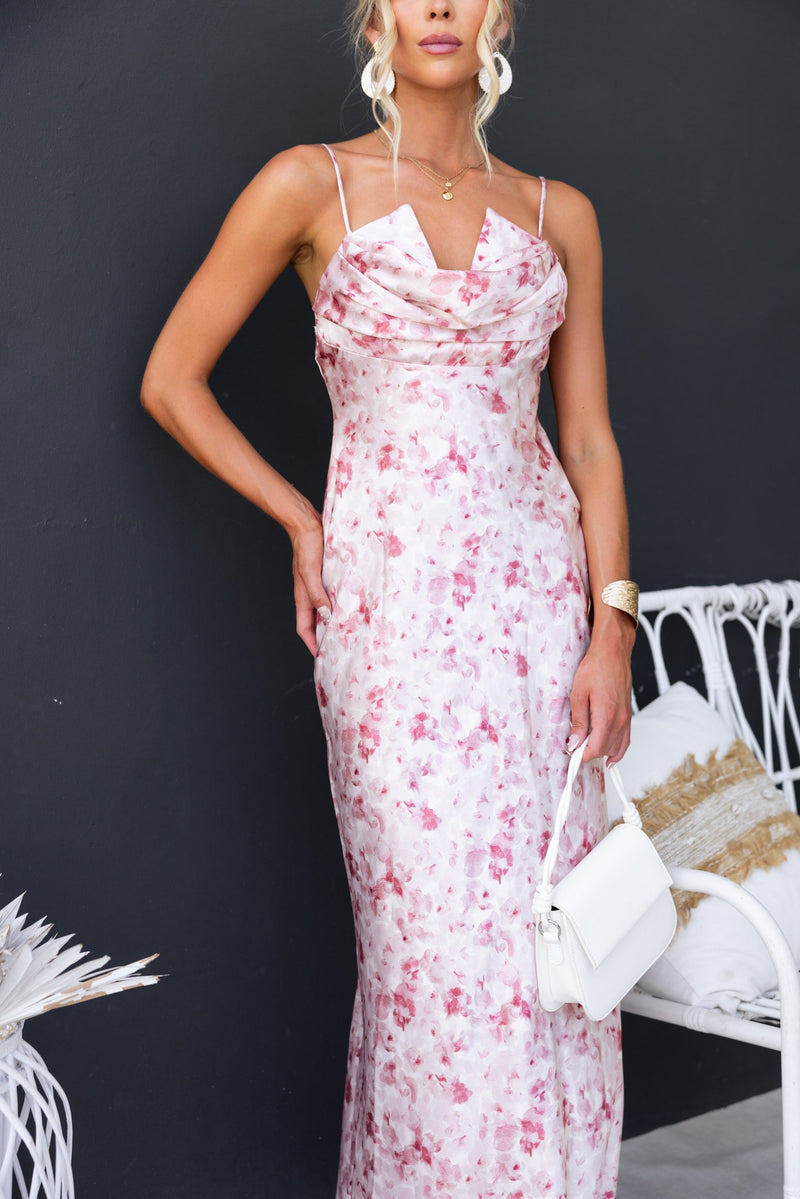 Floral print Villa Maxi Dress with adjustable straps and draping fabric, styled with a white handbag.