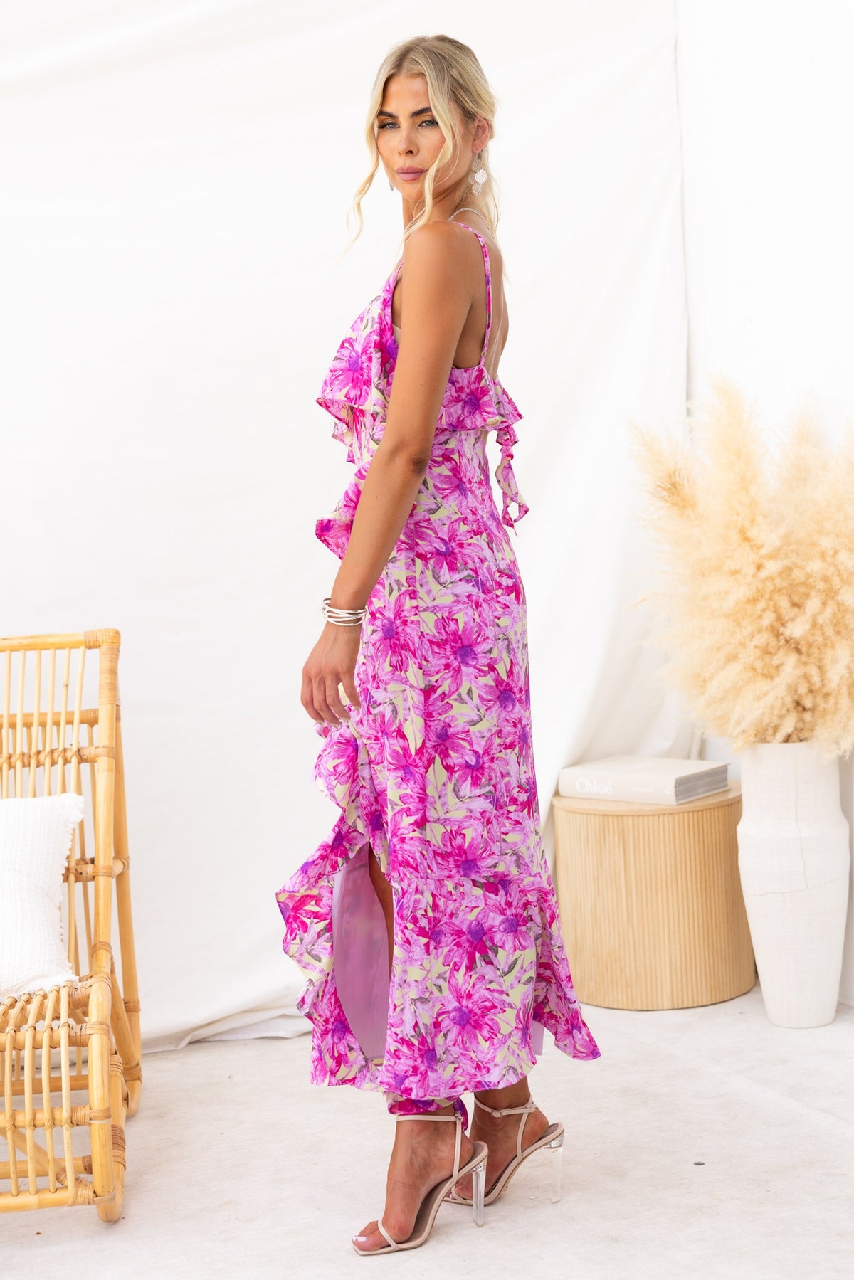 Back view of Anissa Maxi Dress, featuring a floral print, adjustable straps, and ruffles, perfect for summer events.