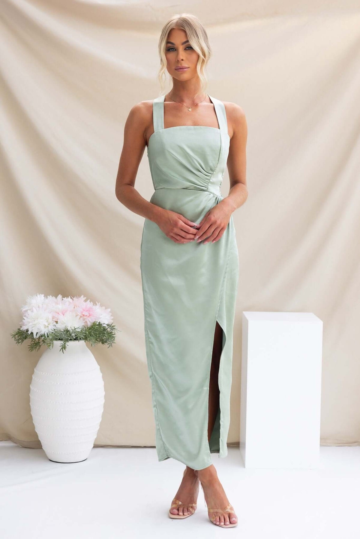 Stylish model wearing a green Merritt Maxi Dress with adjustable straps and a side slit.