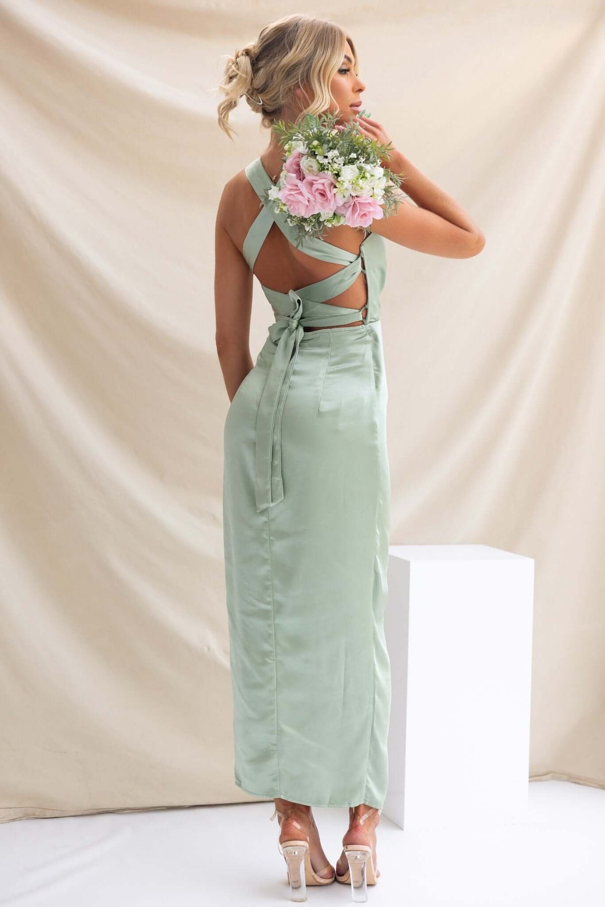 Model showcasing the back of the Merritt Maxi Dress in mint green, featuring adjustable straps and floral bouquet.